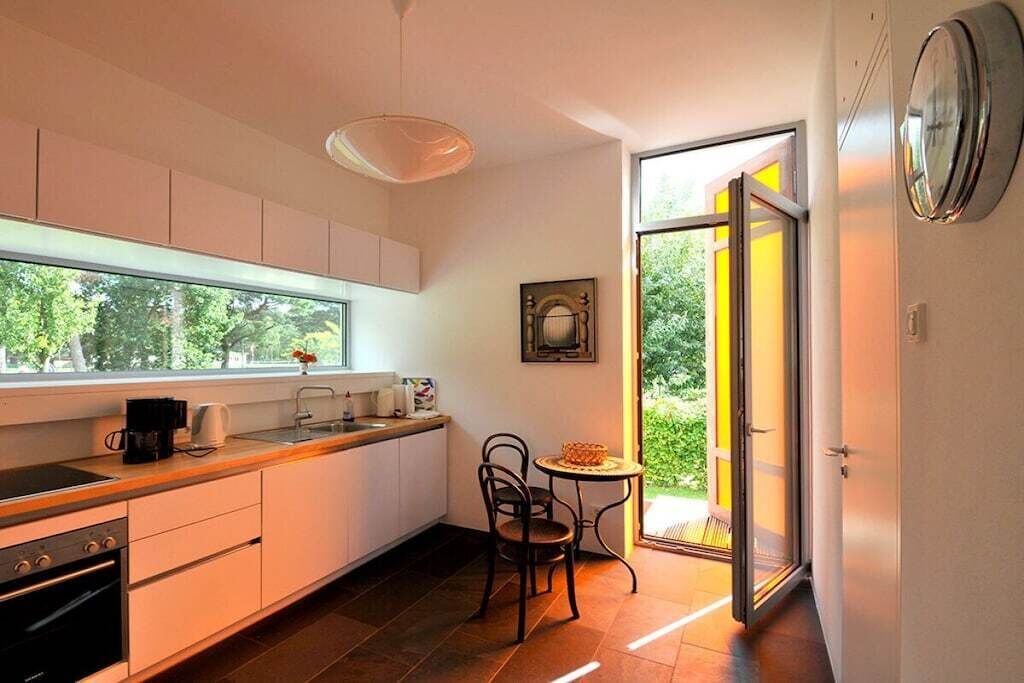Eine moderne Küche mit Essbereich, einer Kaffeemaschine und Blick durch eine Glastür.