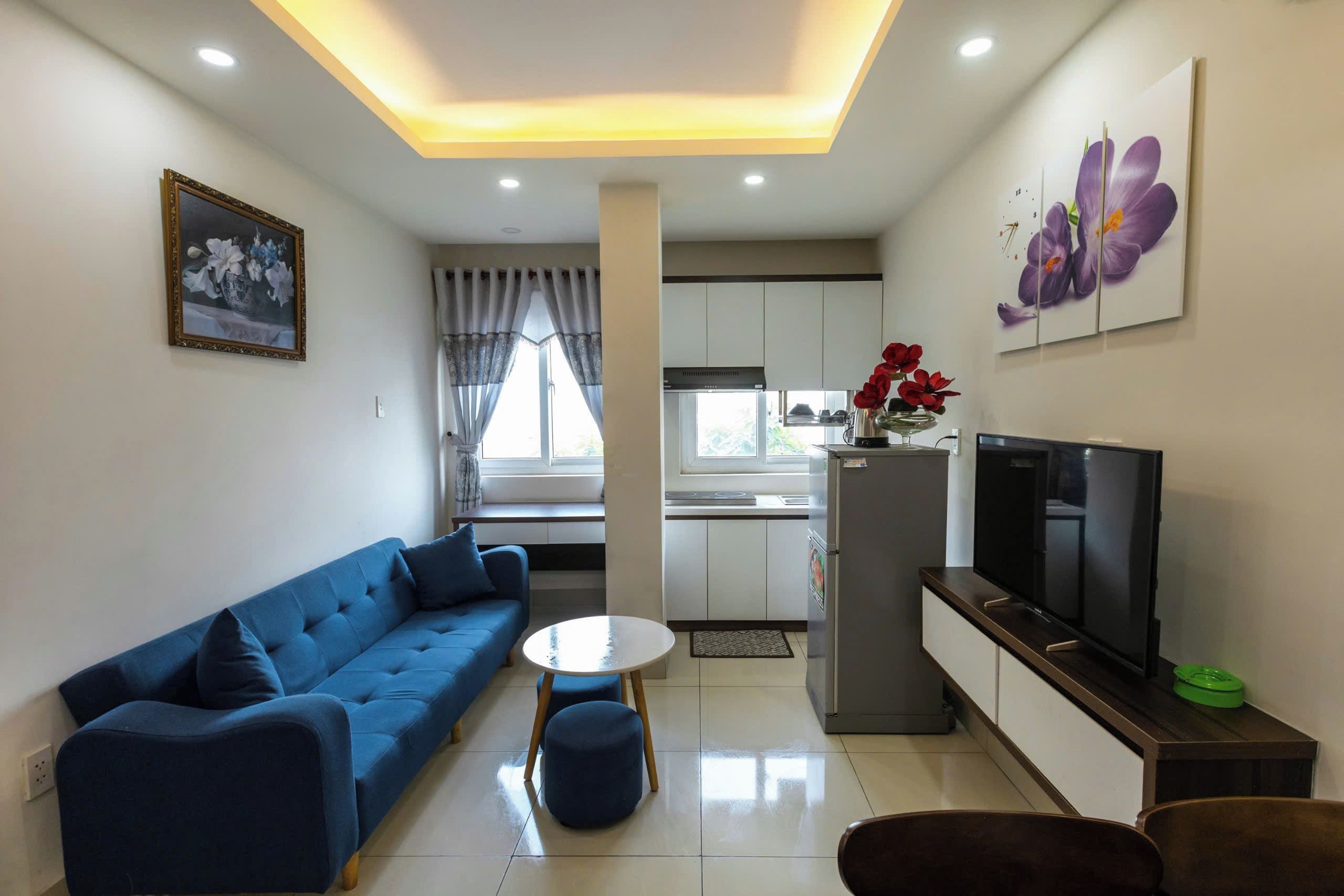 A modern living room with a blue sofa, a coffee table, and a television.