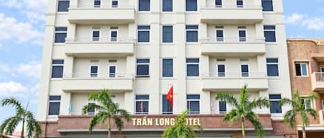 A multi-story hotel with a prominent sign reading 'TRÁN LONG HOTEL'.