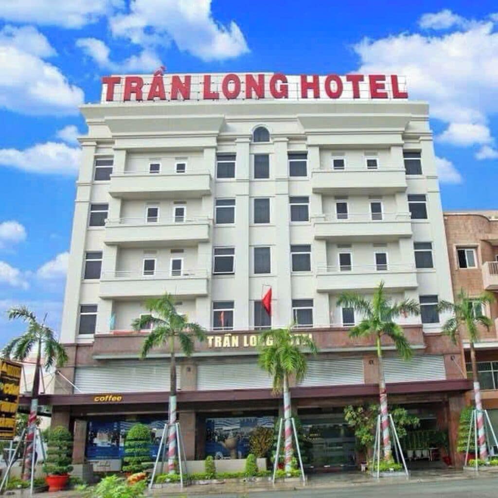 A multi-story hotel building with a prominent sign reading 'TRÁN LONG HOTEL'.