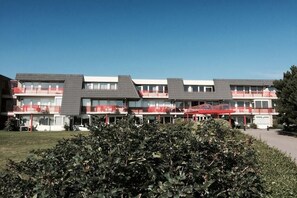 Ein mehrgeschossiges Hotel mit Balkonen und blauem Himmel.
