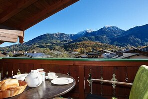A table set with white dishes and bread, overlooking a mountainous landscape with houses. - Jenner in the Thiele House (Schönau am Königssee)