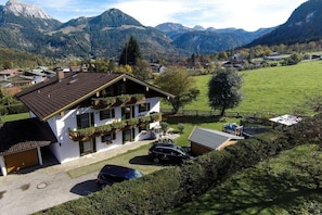 A two-story house with a sloped roof, a garage, and a car parked in the driveway. - Jenner in the Thiele House (Schönau am Königssee)