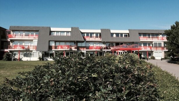 Ein mehrstöckiges Hotel mit Balkonen und einem wolkenlosen Himmel.
