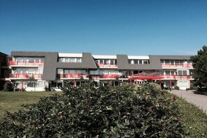 A multi-story hotel with balconies and a clear sky. - Amelander Paradijs 39 (KA Buren)