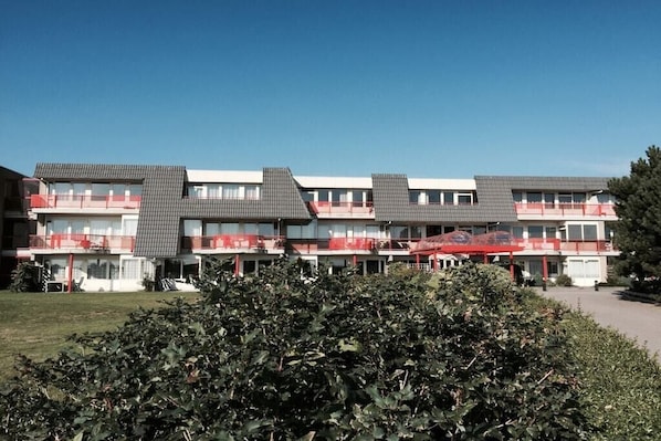 A multi-story hotel with balconies and a clear sky. - Amelander Paradijs 39 (KA Buren)