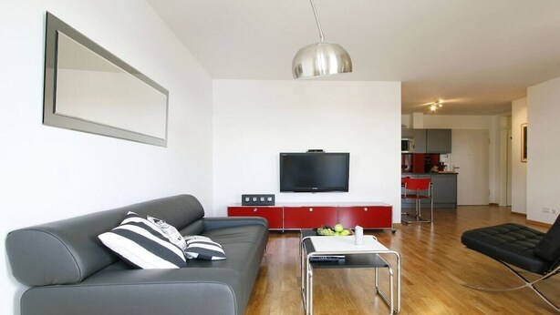 Een moderne woonkamer met een bank, een salontafel en een televisie.
