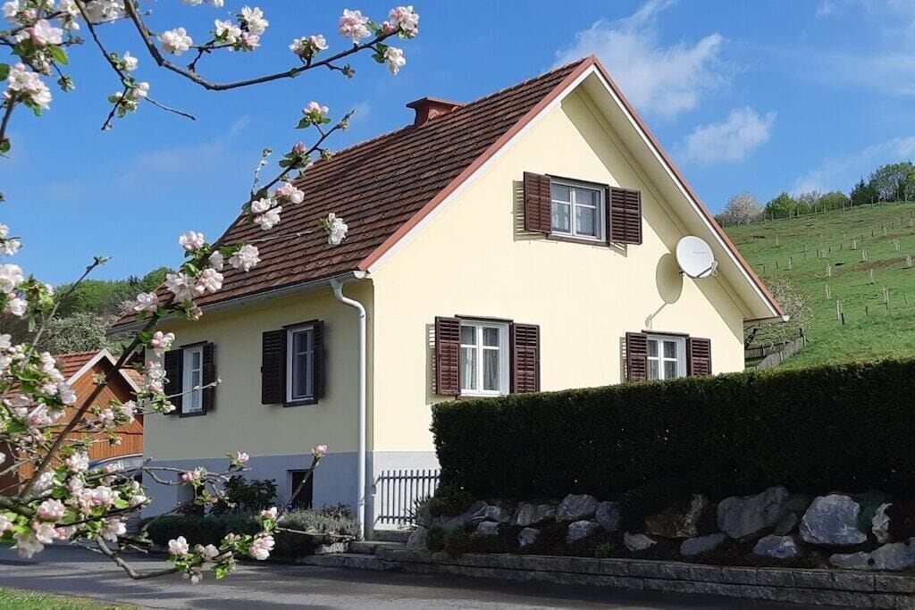A two-story house with a sloped roof, a satellite dish, and a well-maintained lawn.