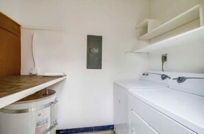 A laundry room with a washing machine, a drying rack, and a bucket. - Beautiful 2-bedroom townhome in delightful San Diego near the beach (San Diego)