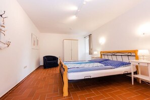Un dormitori amb un llit, escriptori, cadira i armari.