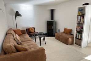 A modern living room with a sofa, a coffee table, a bookshelf, and a fireplace. - Holiday home with 3 bedrooms (Carpentras)