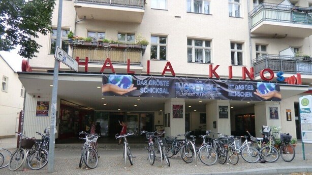 A building with a sign that reads 'HALIA KINO' and several bicycles parked in front. - Holiday apartment with 1 bedroom (Potsdam)