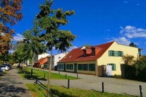 Eine Straße mit Häusern, blauem Himmel und einem Bürgersteig.