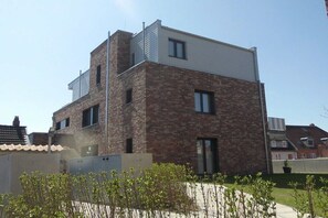 A modern two-story building with a brick facade and a flat roof. - Holiday apartment Husumer Wattwurm (Husum)