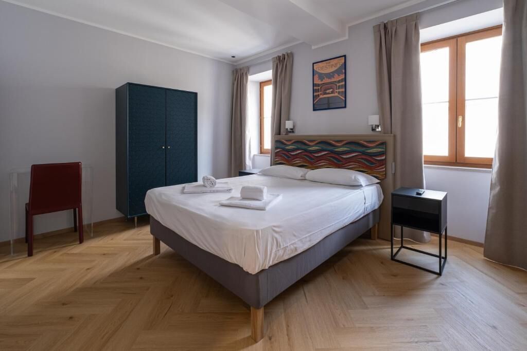 Una camera da letto con un letto, un armadio, una sedia e un comodino.
