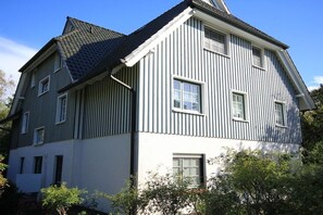 A two-story building with a gabled roof and vertical siding. - Holiday apartment with 1 bedroom (Zingst)