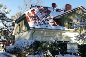 A building with a sloped roof covered in snow, a satellite dish, and a sign indicating it is a private residence. - Holiday home in Prerow with swimming pool (Prerow)