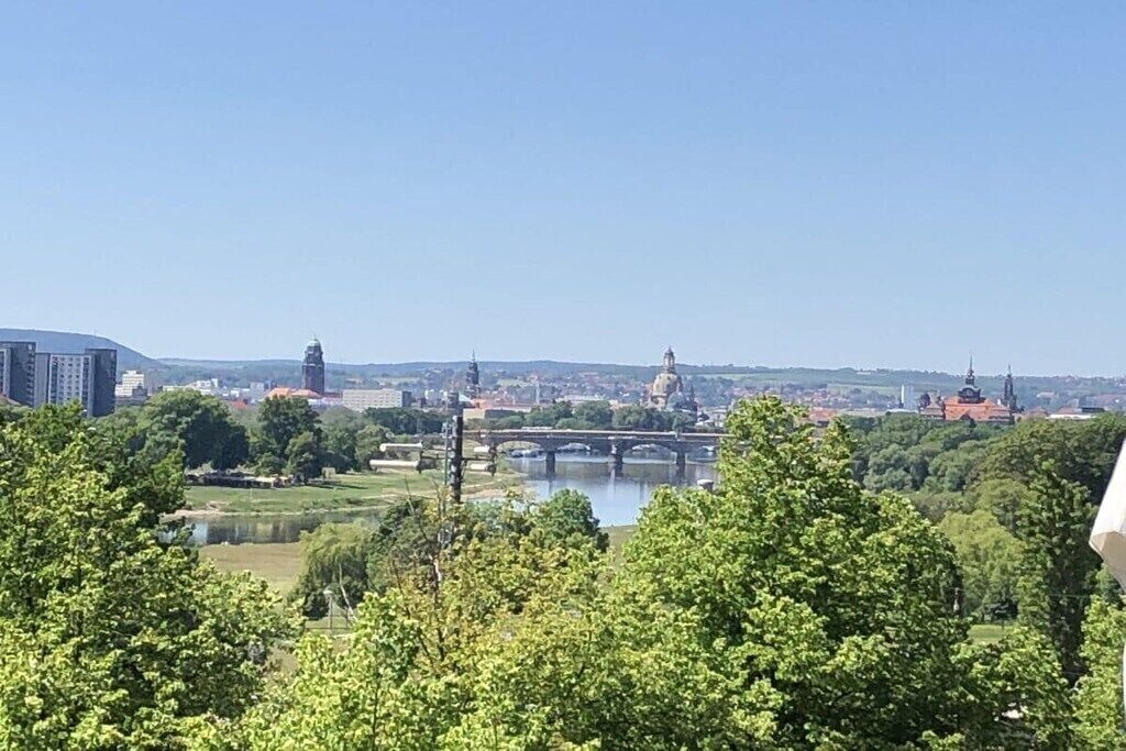 Eine Stadtansicht mit einem Fluss, Brücken und Gebäuden, darunter eine markante Kuppelstruktur.