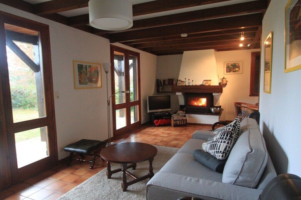Una sala acogedora con chimenea, un sofá, un televisor y una mesa de comedor.