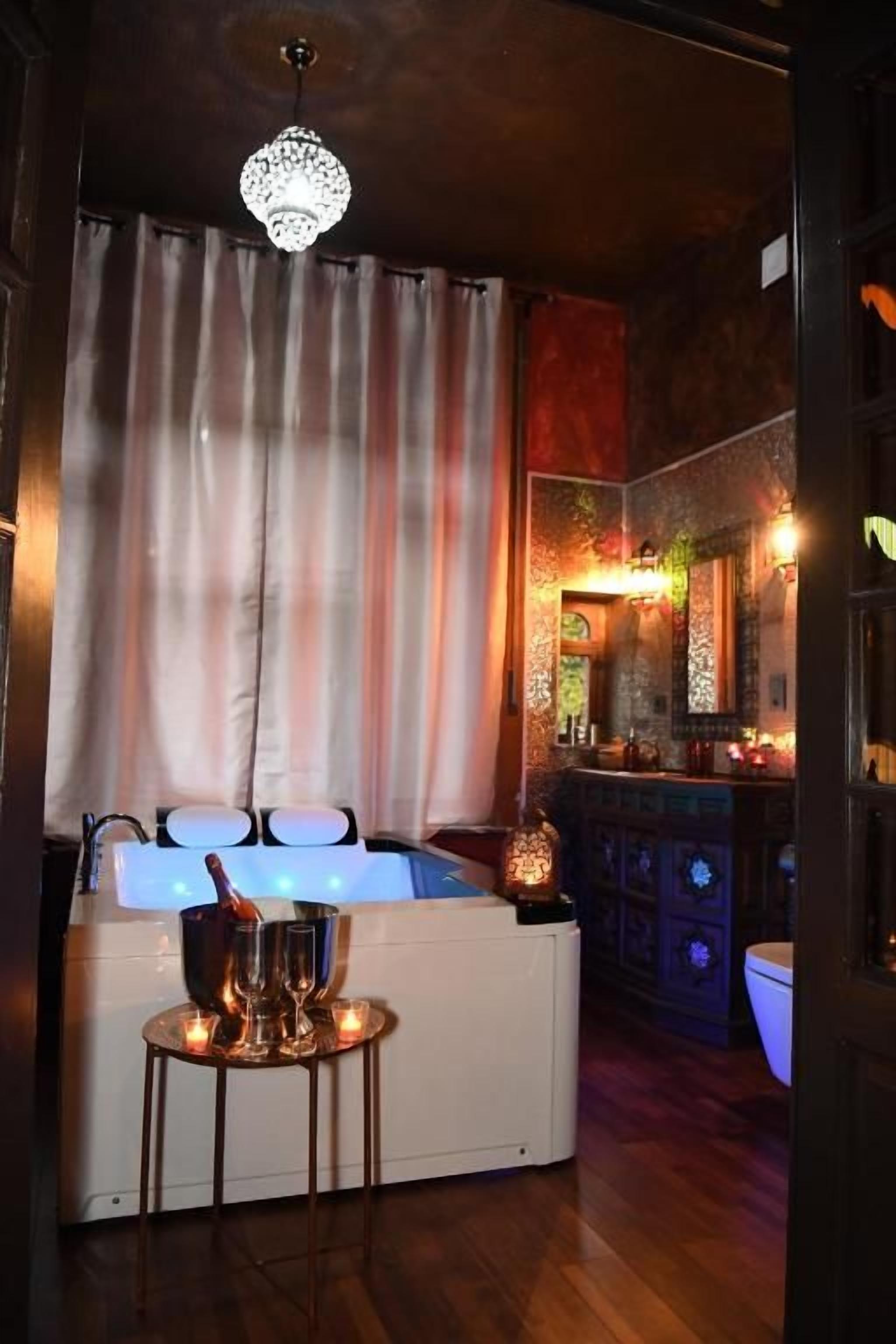 Une pièce comprenant un coin bar, un évier avec une bouteille et un lustre.