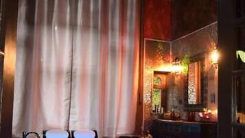 Une pièce comprenant un coin bar, un évier avec une bouteille et un lustre.