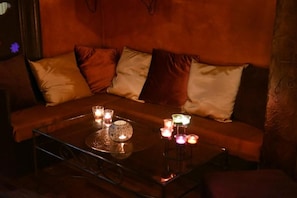 A dimly lit room with a sofa and a glass coffee table.