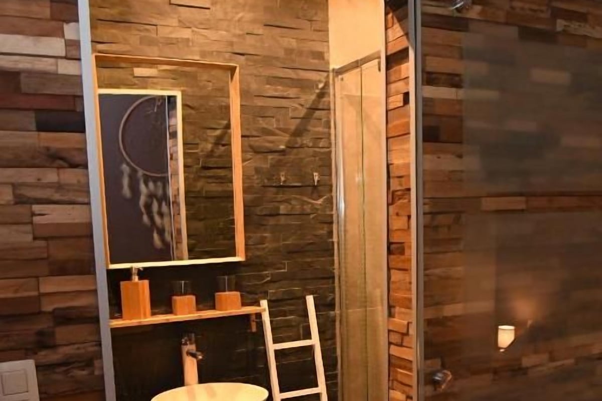 Een badkamer met een houten wand, een wastafel en een ladder.