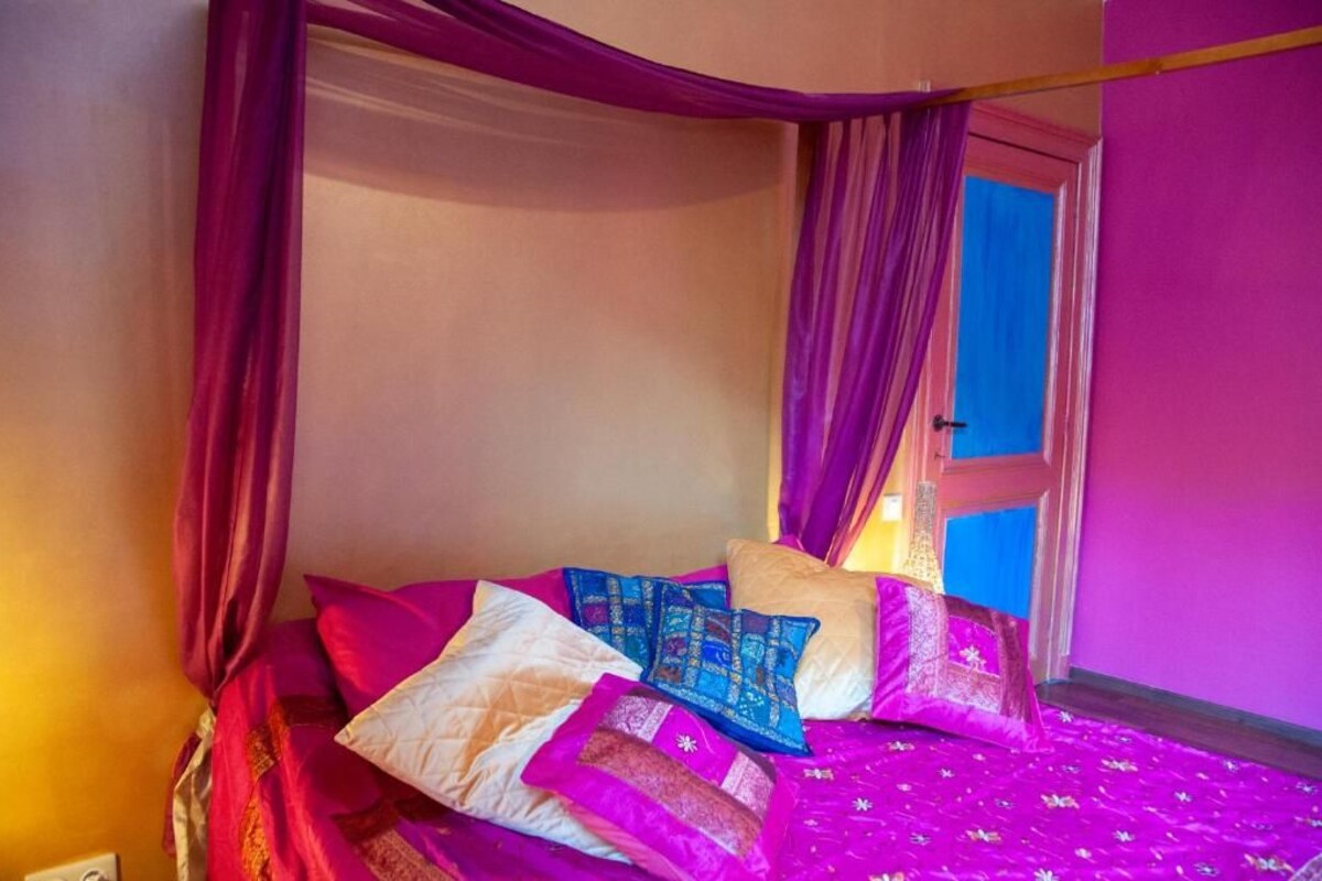 Una cama con muchas almohadas y dosel.