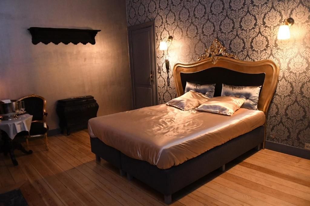 Un dormitorio con una cama grande, una mesita de noche, un aparador y una estantería en la pared.