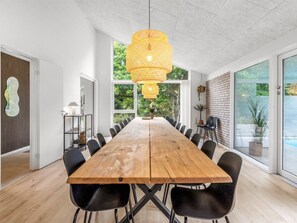 A modern conference room with a wooden table, black chairs, and a large hanging light fixture. - "Filippine" - 800m from the sea by Interhome (Glesborg)