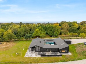 A modern house with a swimming pool, surrounded by a well-maintained lawn and dense trees. - "Filippine" - 800m from the sea by Interhome (Glesborg)