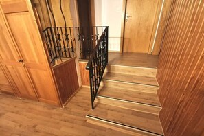 Eine Holztreppe mit einem schwarzen Metallgeländer.