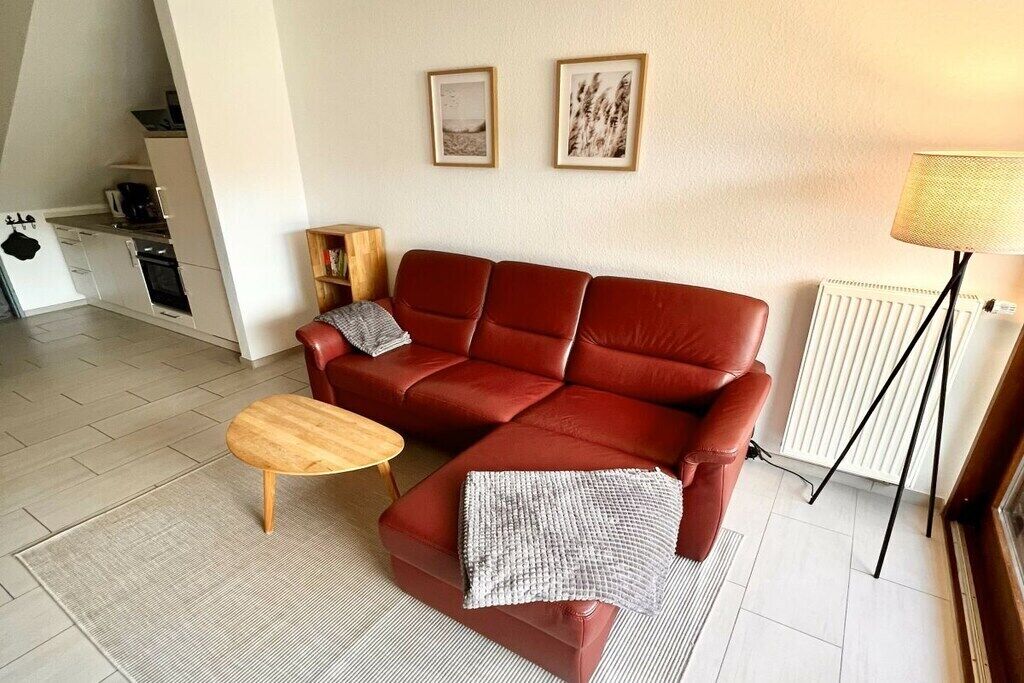 A living room with a red sofa, a wooden coffee table, and a radiator.