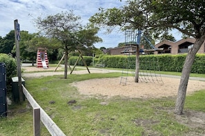A playground with a slide, swings, and climbing structures. - "Little Friesian" Dangast (Varel Dangast)