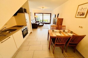 A compact kitchen with a dining area, a microwave, and a dining table set for four. - "Little Friesian" Dangast (Varel Dangast)