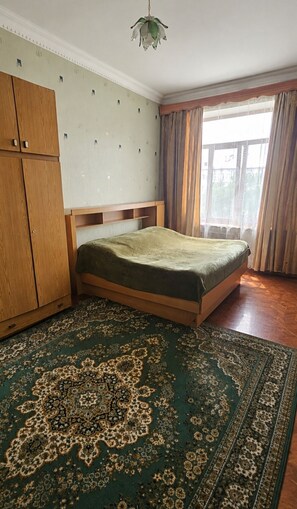 A room with a bed, wardrobe, and a large patterned rug. - Enjoyable 3-bedroom house with AC in charming Gyumri (Gyumri)