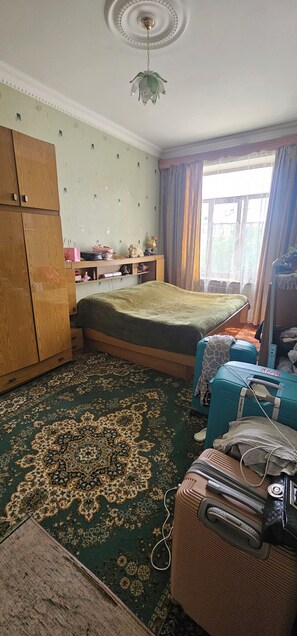 A room with a bed, a wardrobe, a desk, a lamp, and a window with curtains. - Enjoyable 3-bedroom house with AC in charming Gyumri (Gyumri)