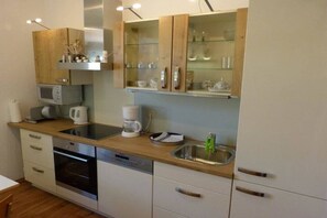 Eine moderne Küche mit Mikrowelle, Kaffeemaschine und Geschirrspüler.