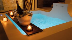 A spa area with a hot tub, candles, and a bottle of champagne. - The Doge's Secret | Wellness Suite with Private Spa in Verona (Verona)