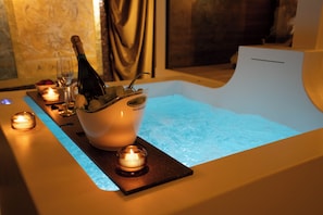 A spa area with a hot tub, candles, and a bottle of champagne. - The Doge's Secret | Wellness Suite with Private Spa in Verona (Verona)