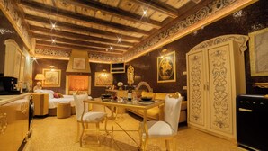 A luxurious room with a high ceiling, ornate wall decorations, a dining area with a table and chairs, and a large wardrobe. - The Doge's Secret | Wellness Suite with Private Spa in Verona (Verona)