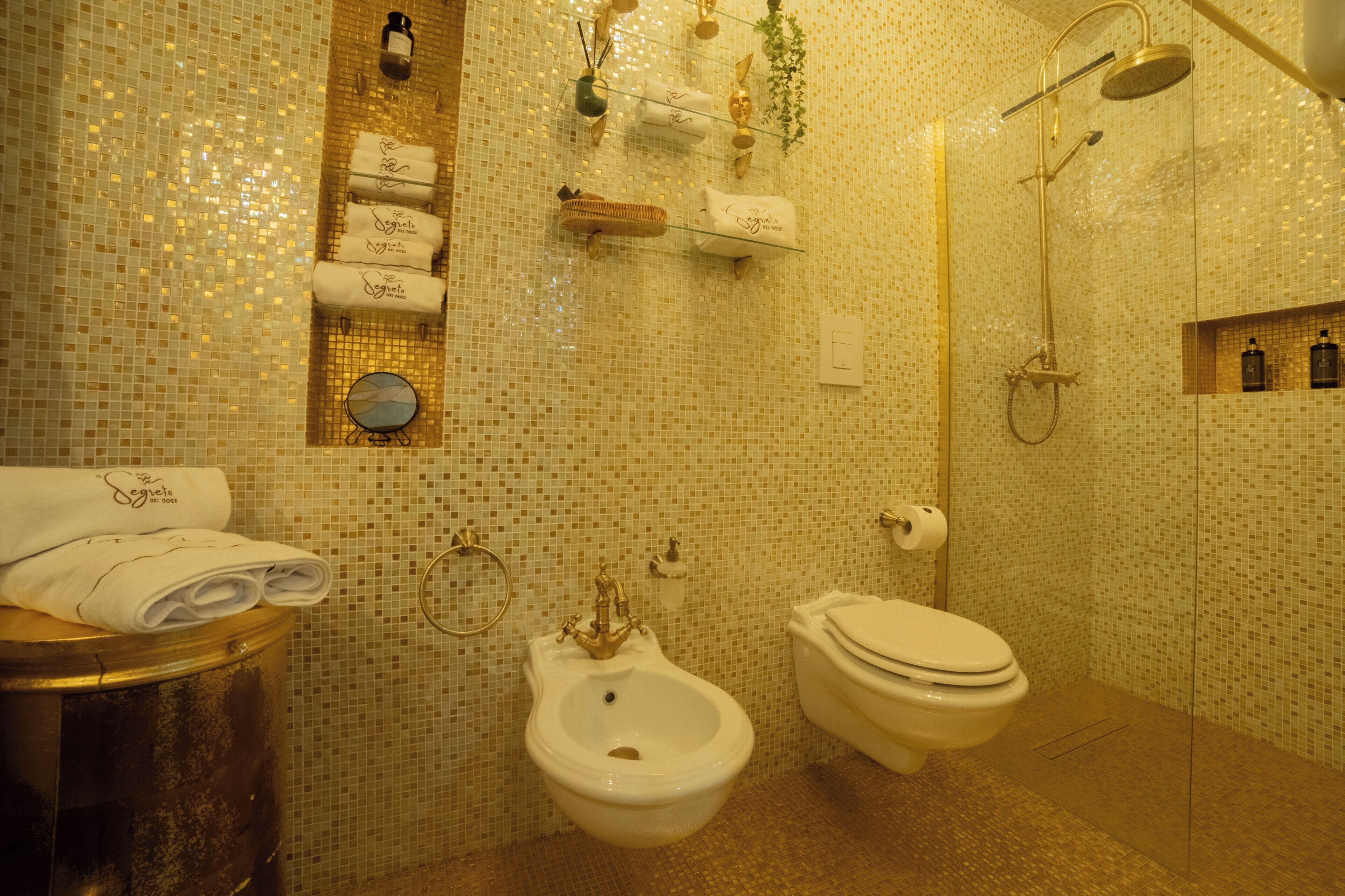 Ein Badezimmer mit einer Bidet-Funktion, Toilette und Waschbecken mit Spiegel.