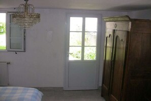A room with a bed, a door, a wardrobe, and a chandelier. - Holiday home with 2 bedrooms (St. Pol de Léon)