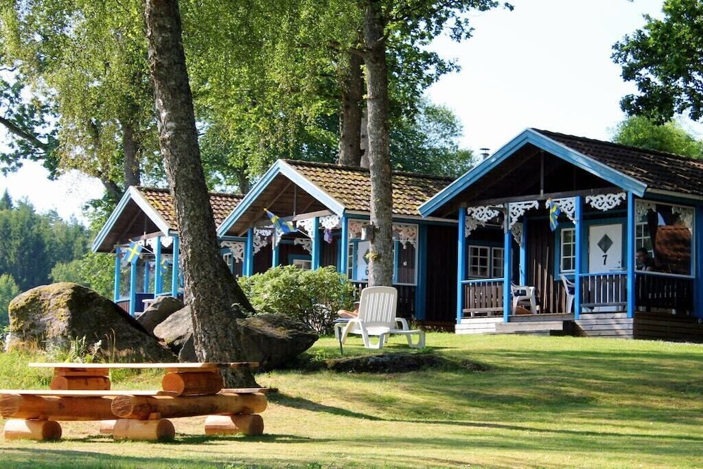 Een rij vakantiehuisjes met een picknicktafel en stoelen ervoor.