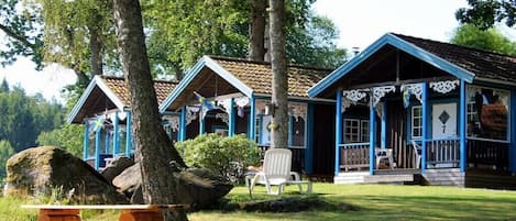 A row of cabins with a picnic table and chairs in front.