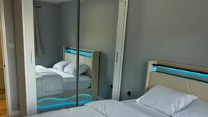 A bedroom with a bed, a wardrobe, and a mirror.