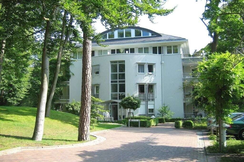 A modern building with a curved facade, large windows, and a central entrance.