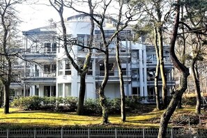 A multi-story building with a modern architectural style, surrounded by trees and a well-maintained lawn. - Carpe Diem Lake Park (Seebad Heringsdorf)