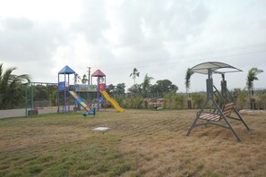 A playground with a slide, swings, and a climbing structure. - Cloud9 Club Resort (A Unit of Dawon Hospitality) (Sasan Gir)