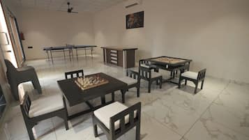 Una habitación con una mesa de ajedrez, una mesa de fútbol de mesa y una mesa de billar.